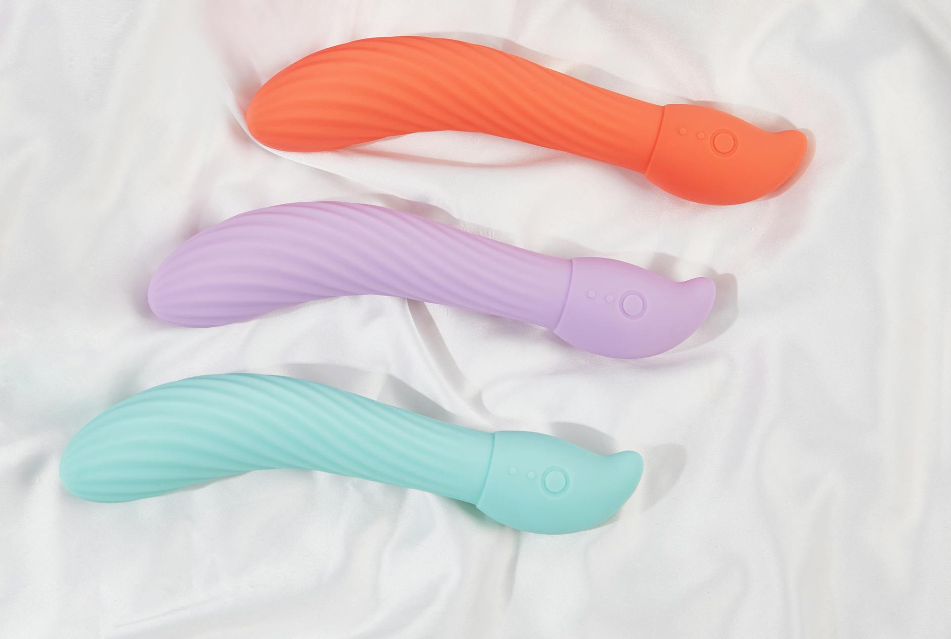 A young couple standing together indoors, holding a blue vibrator, symbolizing modern intimacy and partnership