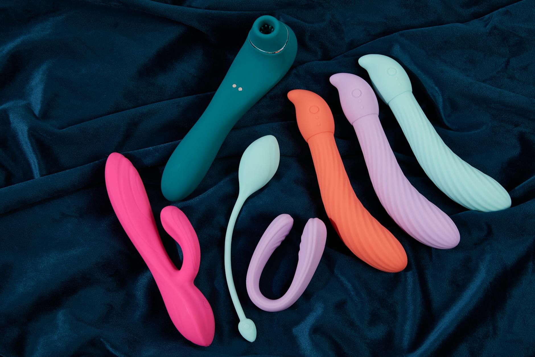 Hand holding a vibrator against a minimalistic purple backdrop