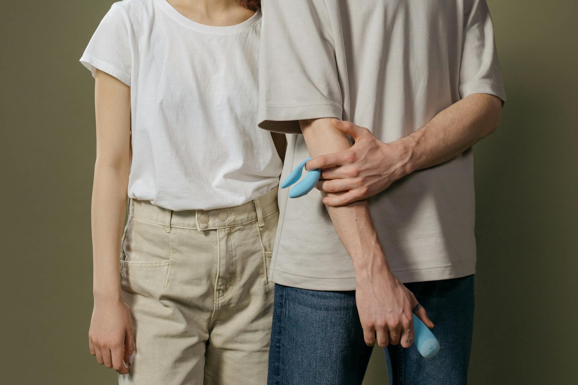 A couple holding intimacy devices together, representing safe exploration and reconnection.